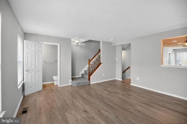 a kitchen with stainless steel appliances wooden floor and windows