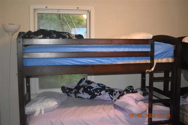 a bedroom with a bed window and mirror