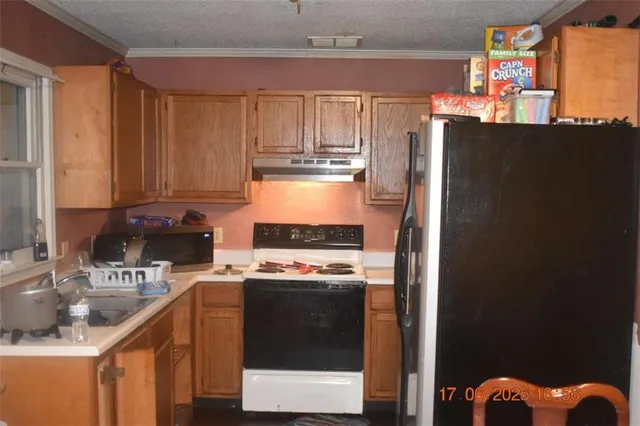 a kitchen with stainless steel appliances granite countertop a refrigerator a stove and a sink