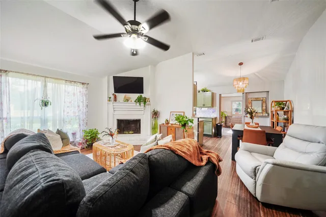 a living room with furniture a fireplace and a flat screen tv