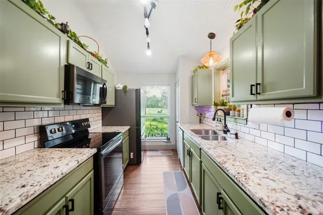 a kitchen with stainless steel appliances granite countertop a sink stove and refrigerator