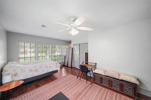 a bedroom with a bed and wooden floor