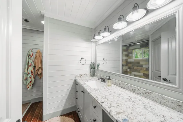 a bathroom with a granite countertop sink mirror and a shower
