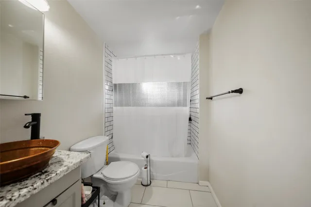 a bathroom with a granite countertop toilet a sink and a mirror