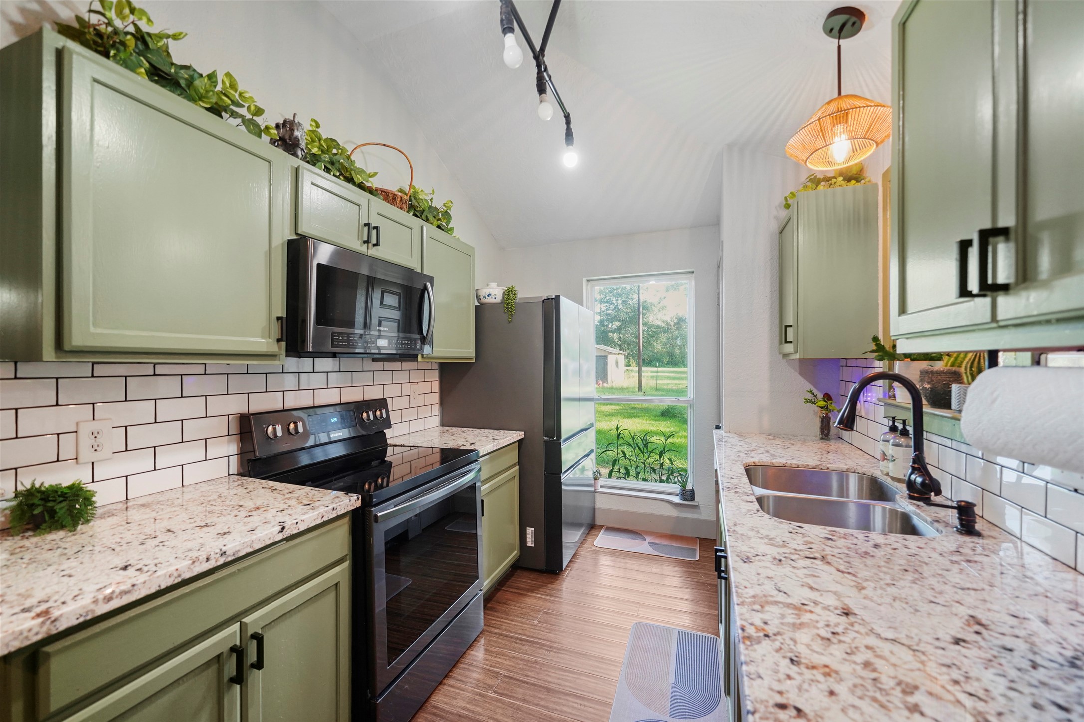 7477 Hidden Acres Drive Cleveland, TX 77328 - Photo 4 of 31 a kitchen with a sink stove and microwave