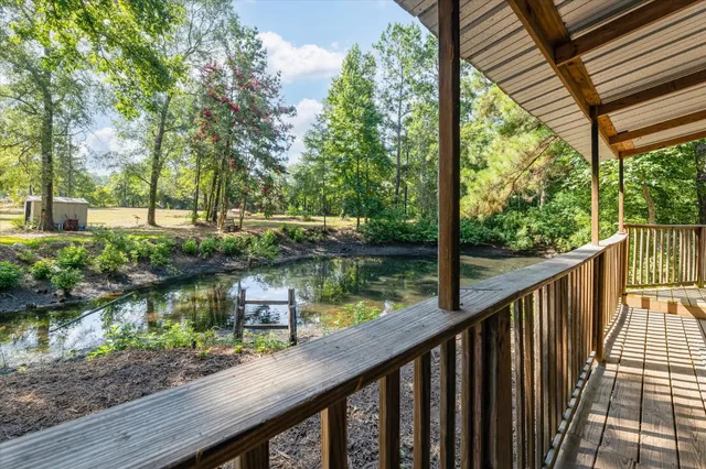a view of a wooden deck and lake from a balcony