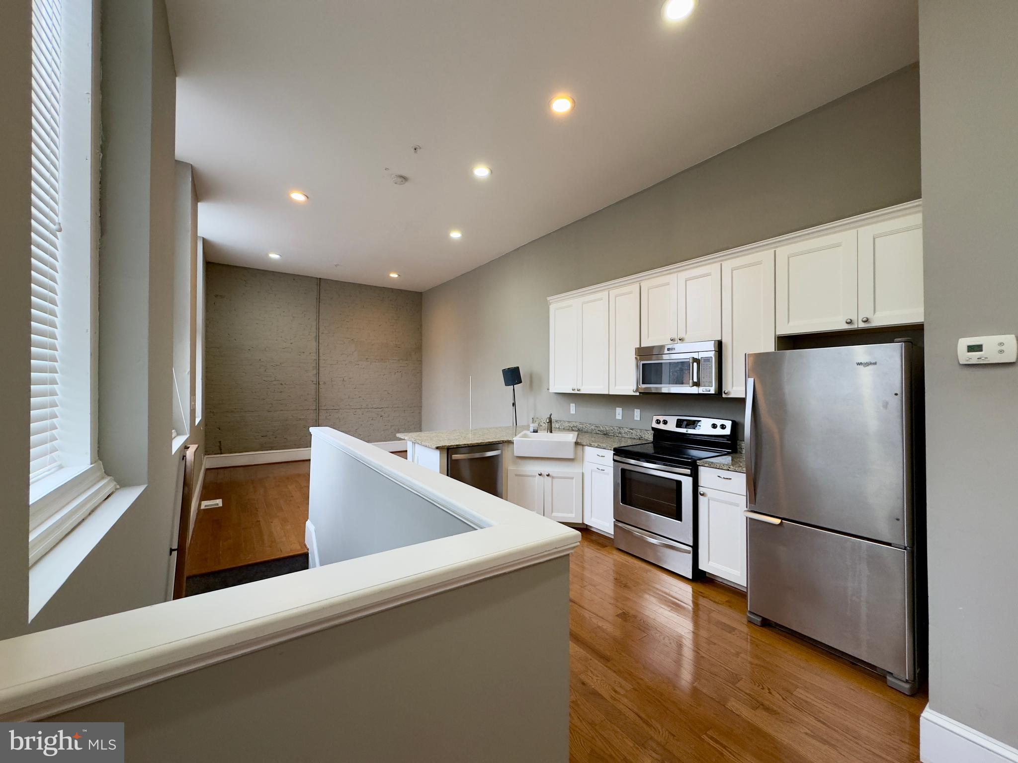 7 West Mulberry Street, Unit 4 Baltimore, MD 21201 - Photo 4 of 19 a kitchen with refrigerator cabinets and wooden floor
