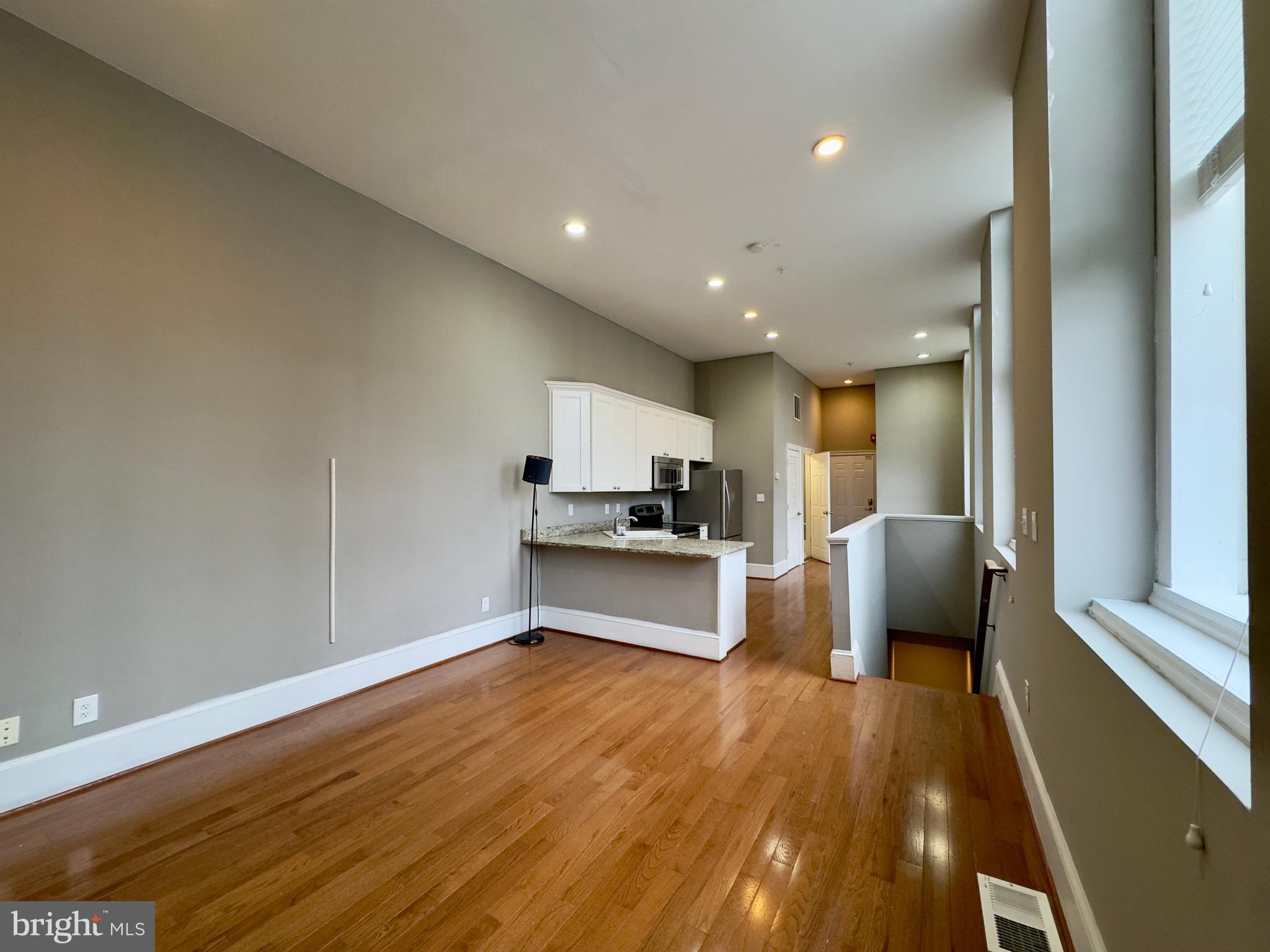 7 West Mulberry Street, Unit 4 Baltimore, MD 21201 - Photo 7 of 19 a large white kitchen with stainless steel appliances granite countertop a refrigerator and a stove