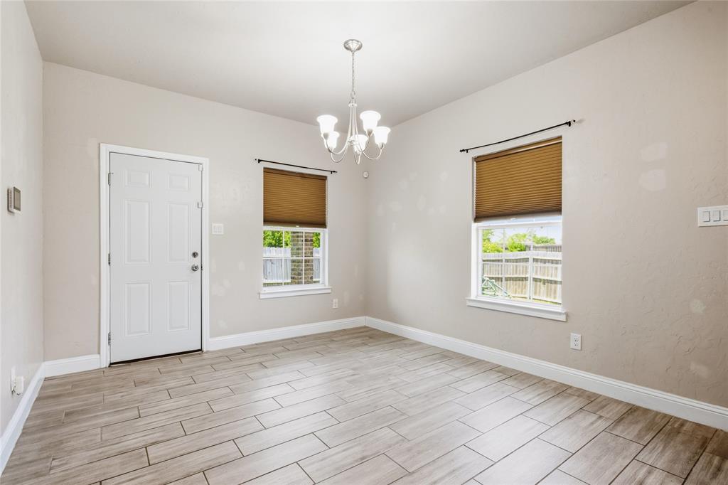 1502 Reed Street Greenville, TX 75401 - Photo 13 of 26 Spacious room with light-toned tile flooring, neutral wall paint, and a chandelier light fixture