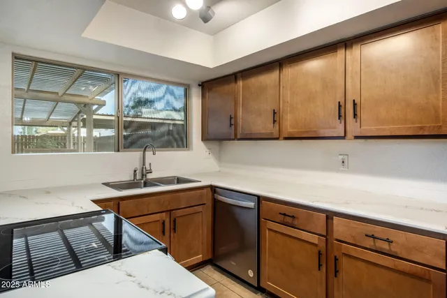 a kitchen with stainless steel appliances granite countertop a sink a stove and cabinets