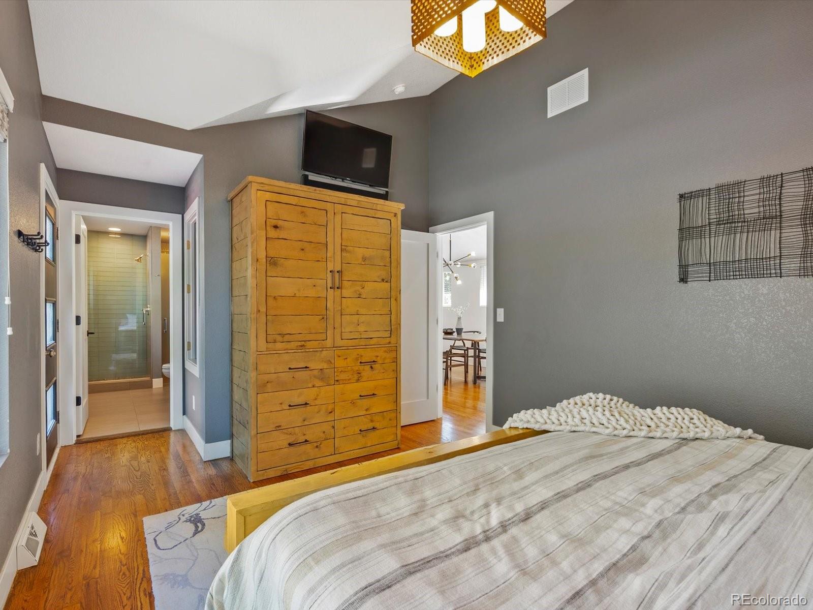 2289 Hudson Street Denver, CO 80207 - Photo 16 of 44 a bedroom with a bed and wooden floor