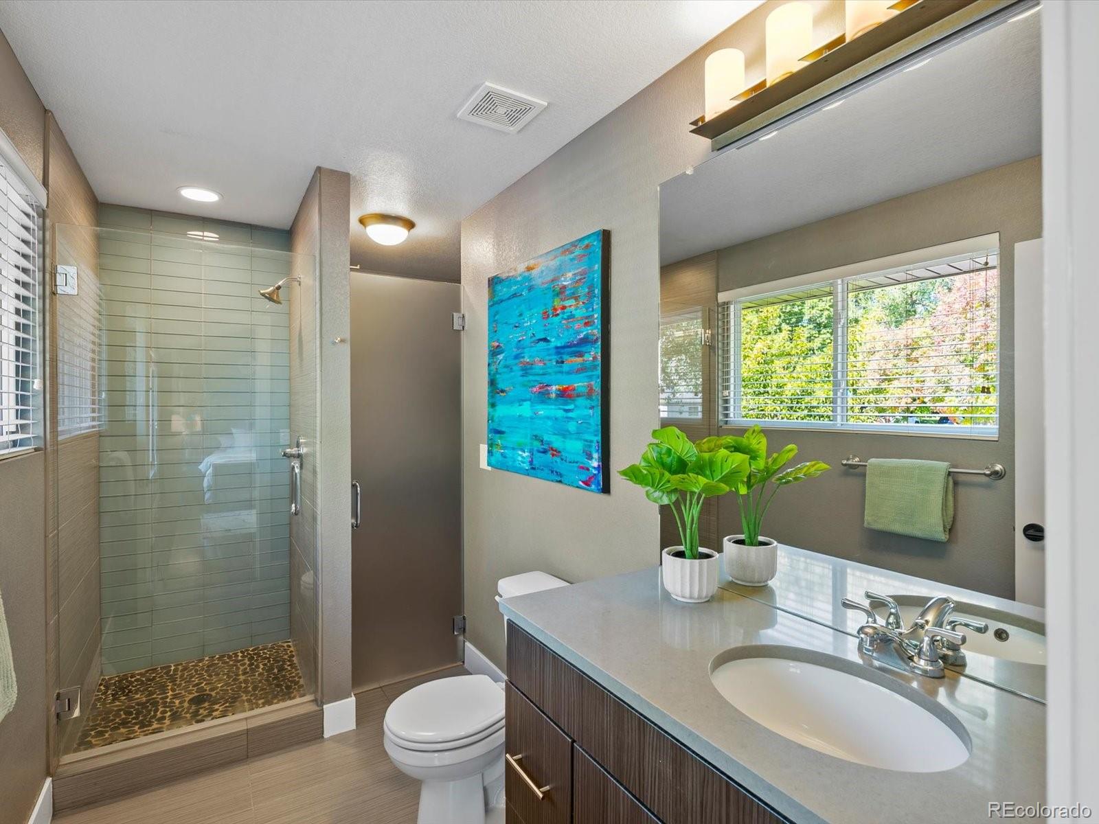 2289 Hudson Street Denver, CO 80207 - Photo 17 of 44 a bathroom with a granite countertop sink a toilet a large mirror and shower