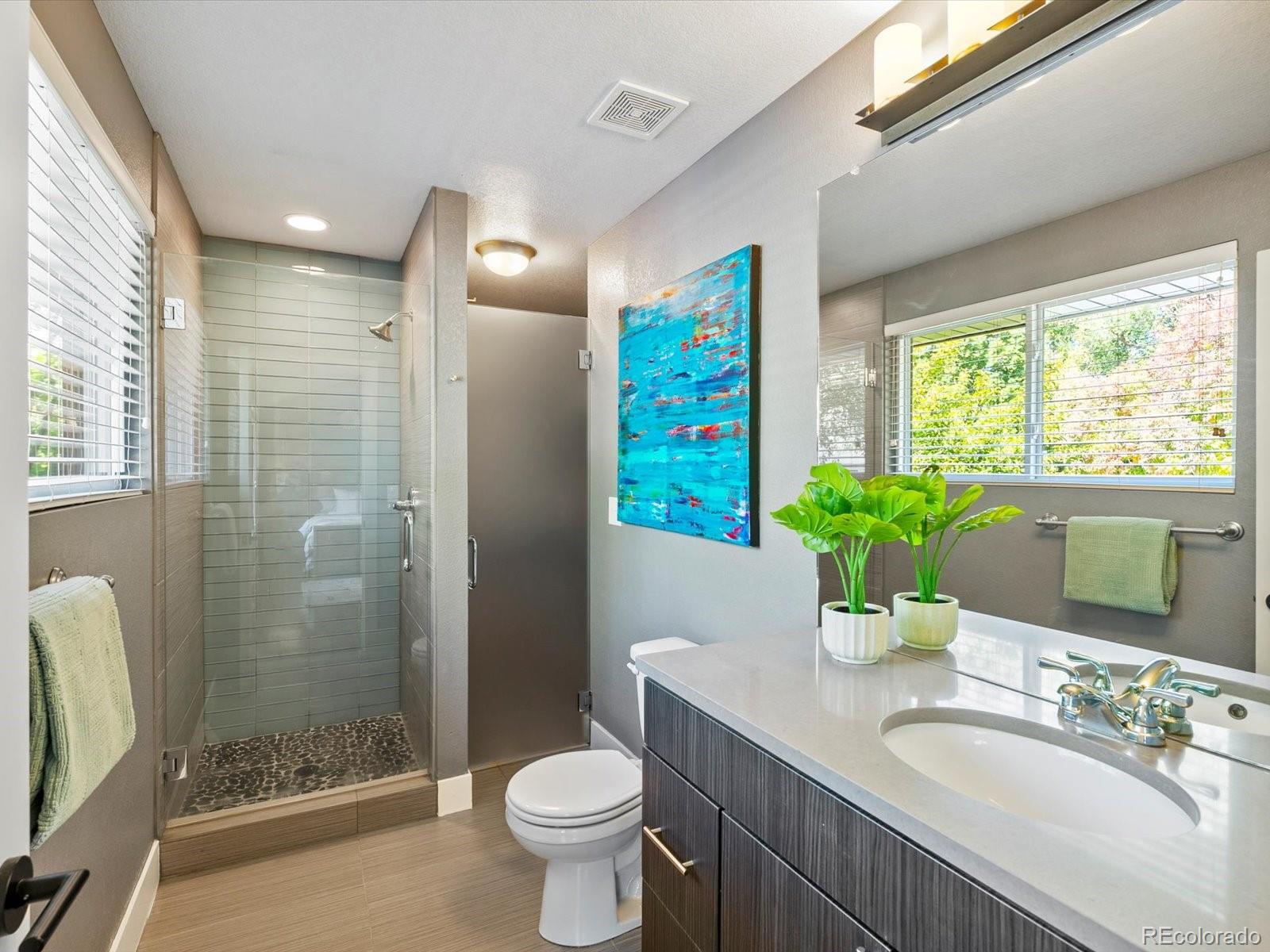 2289 Hudson Street Denver, CO 80207 - Photo 19 of 44 a bathroom with a granite countertop sink toilet a large mirror a bathtub and shower