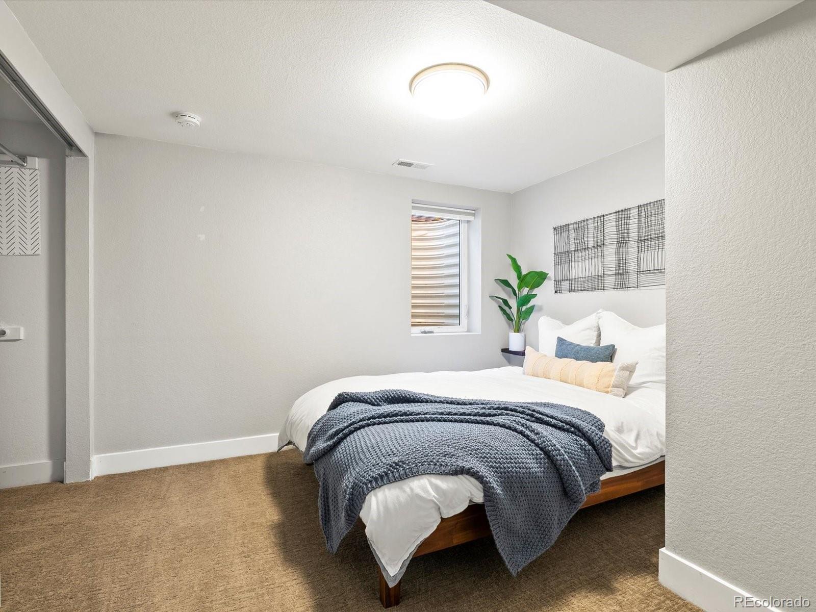 2289 Hudson Street Denver, CO 80207 - Photo 26 of 44 a bedroom with a bed lamp and a window