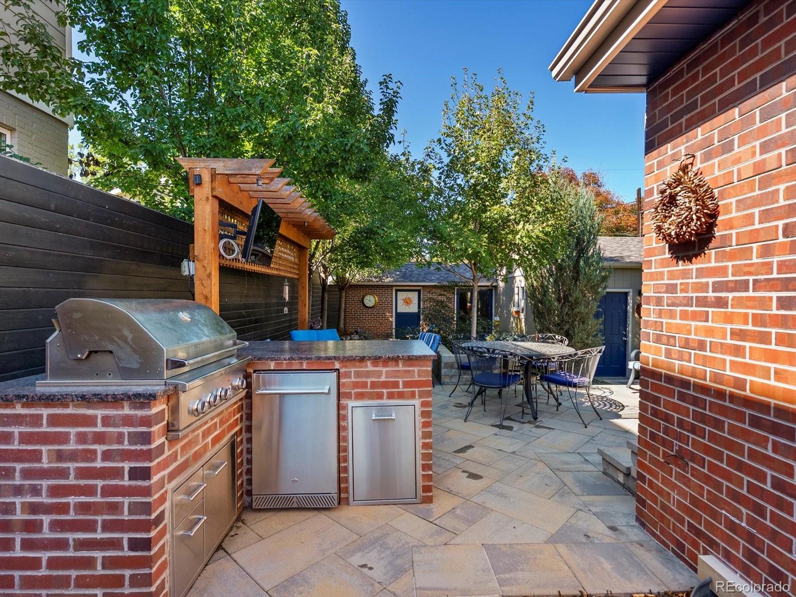 2289 Hudson Street Denver, CO 80207 - Photo 29 of 44 a view of a chairs and table in the back yard of the house