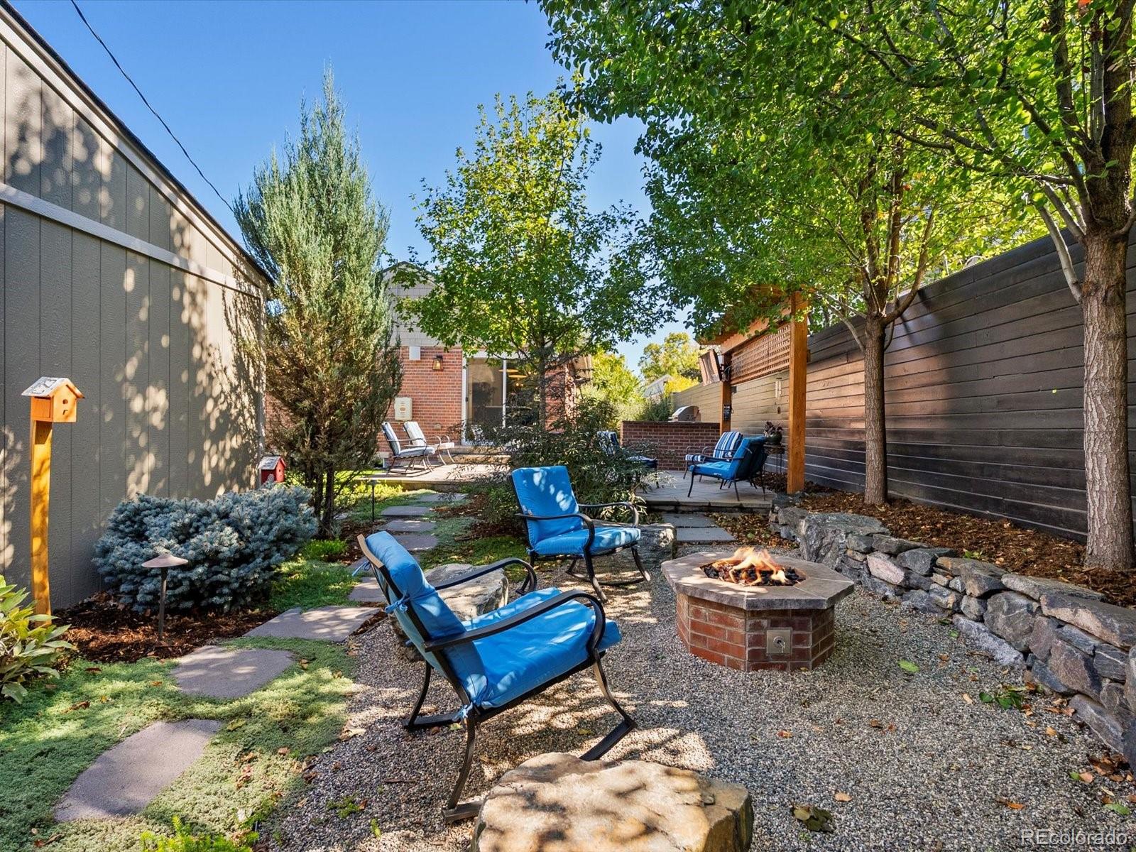 2289 Hudson Street Denver, CO 80207 - Photo 36 of 44 a backyard of a house with barbeque oven table and chairs