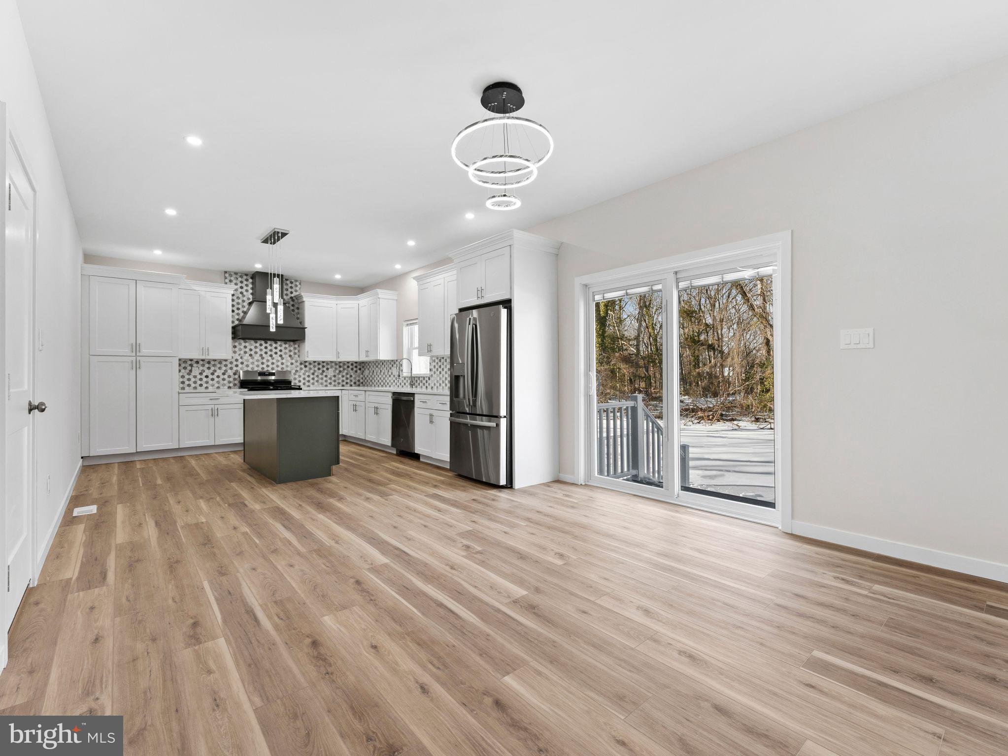 1795 Coles Mill Road Franklinville, NJ 08322 - Photo 12 of 57 a view of a kitchen with stainless steel appliances wooden floor and a large window