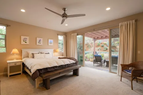 a bedroom with a bed couch and large window