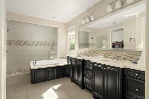 a spacious bathroom with a granite countertop sink and a bathtub