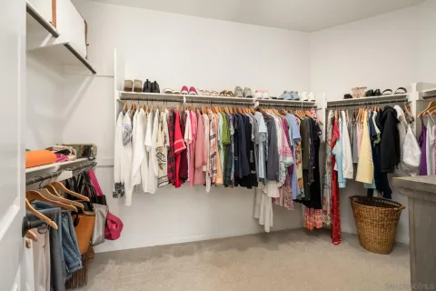a view of walk in closet with clothes