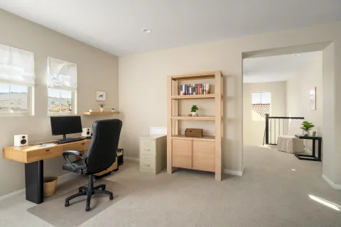 a view of a workspace with furniture and a window