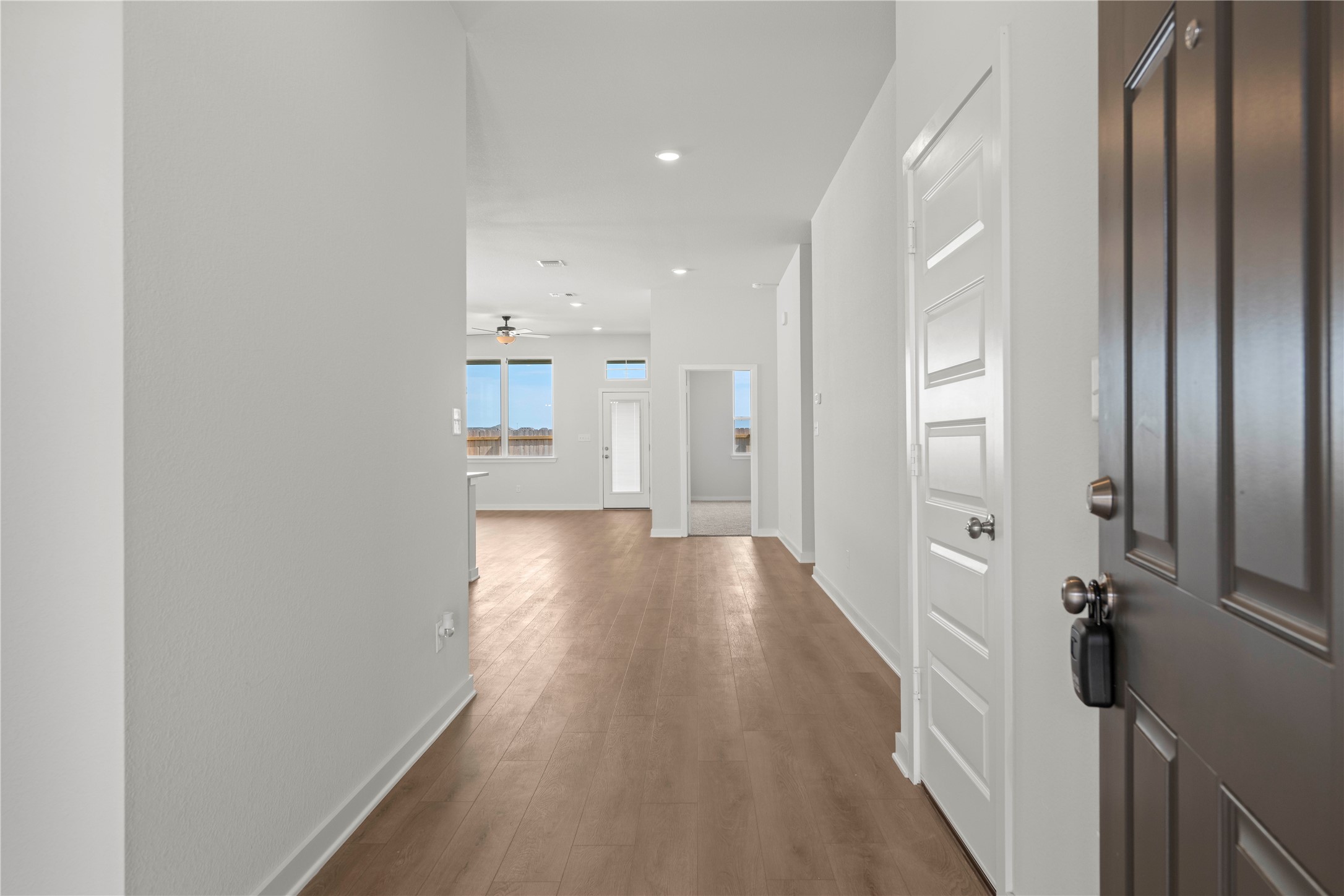220 Gus Loop Georgetown, TX 78626 - Photo 3 of 18 Step into a luminous entryway, revealing sleek wood flooring and a spacious open-concept interior.