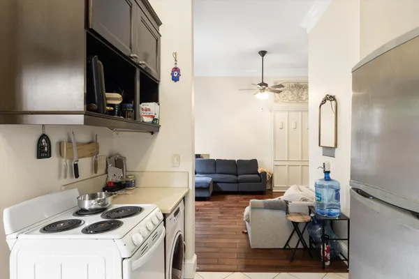 a living room with furniture a flat screen tv and a ceiling fan