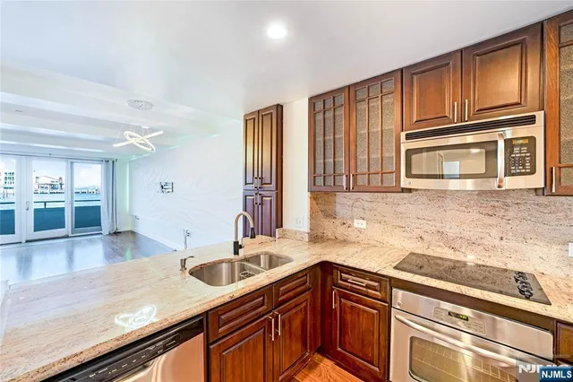 a kitchen with granite countertop stainless steel appliances window a sink and cabinets