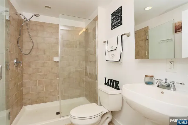 a bathroom with a shower toilet and sink