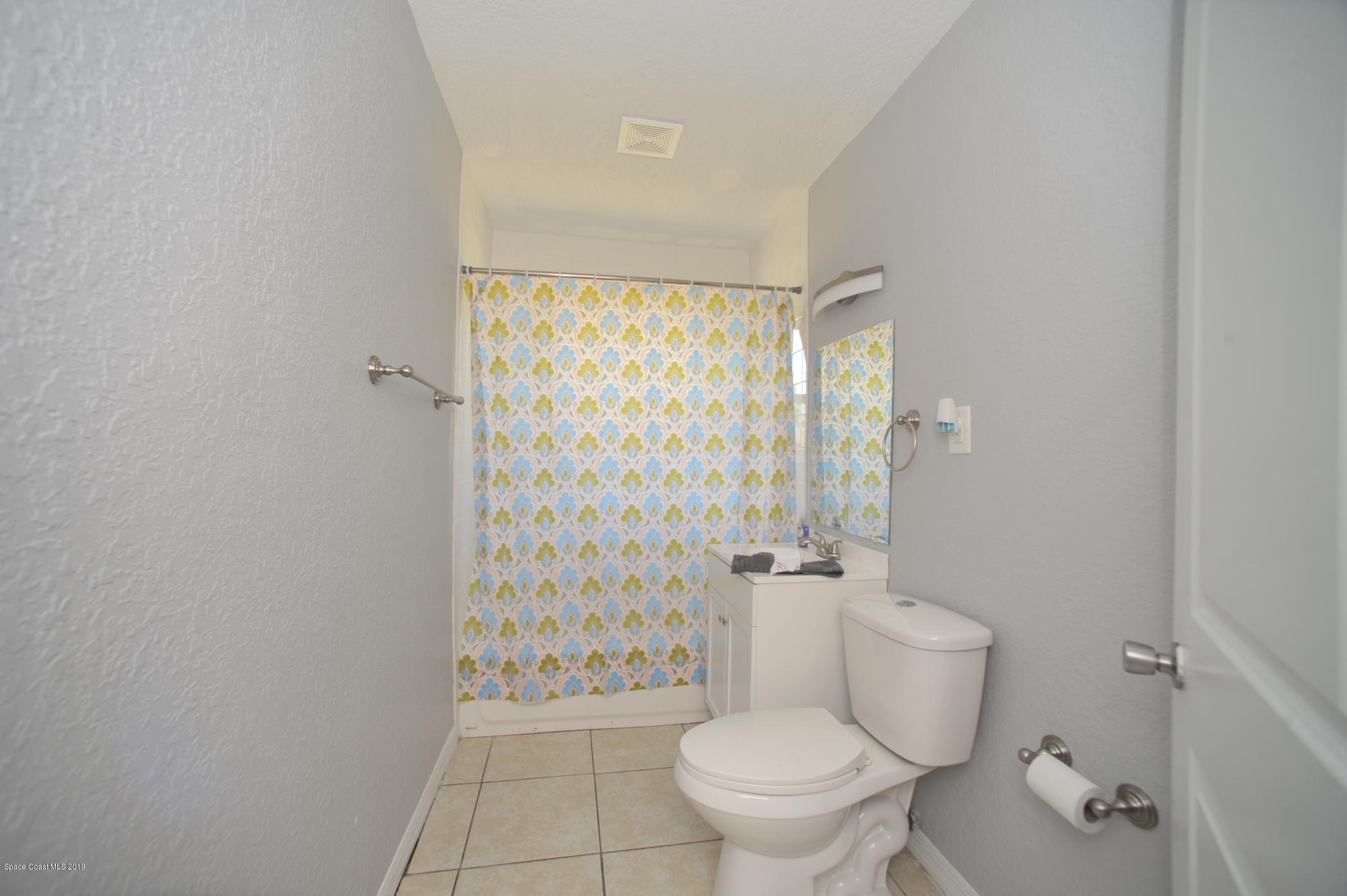 1049 Mitchell Street Cocoa, FL 32922 - Photo 8 of 12 a white toilet sitting next to a shower curtain