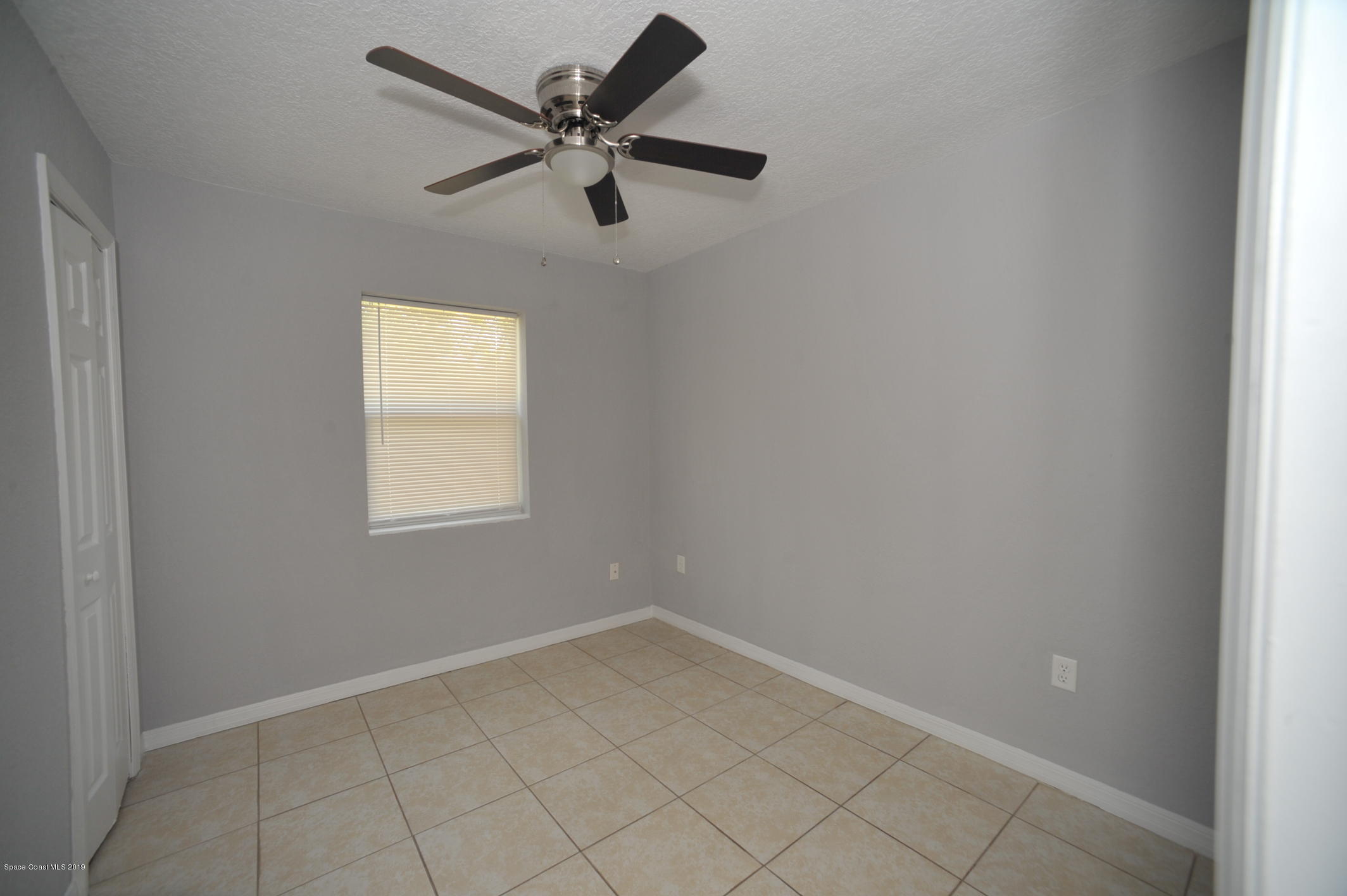 1049 Mitchell Street Cocoa, FL 32922 - Photo 10 of 12 an empty room with a window and a fan