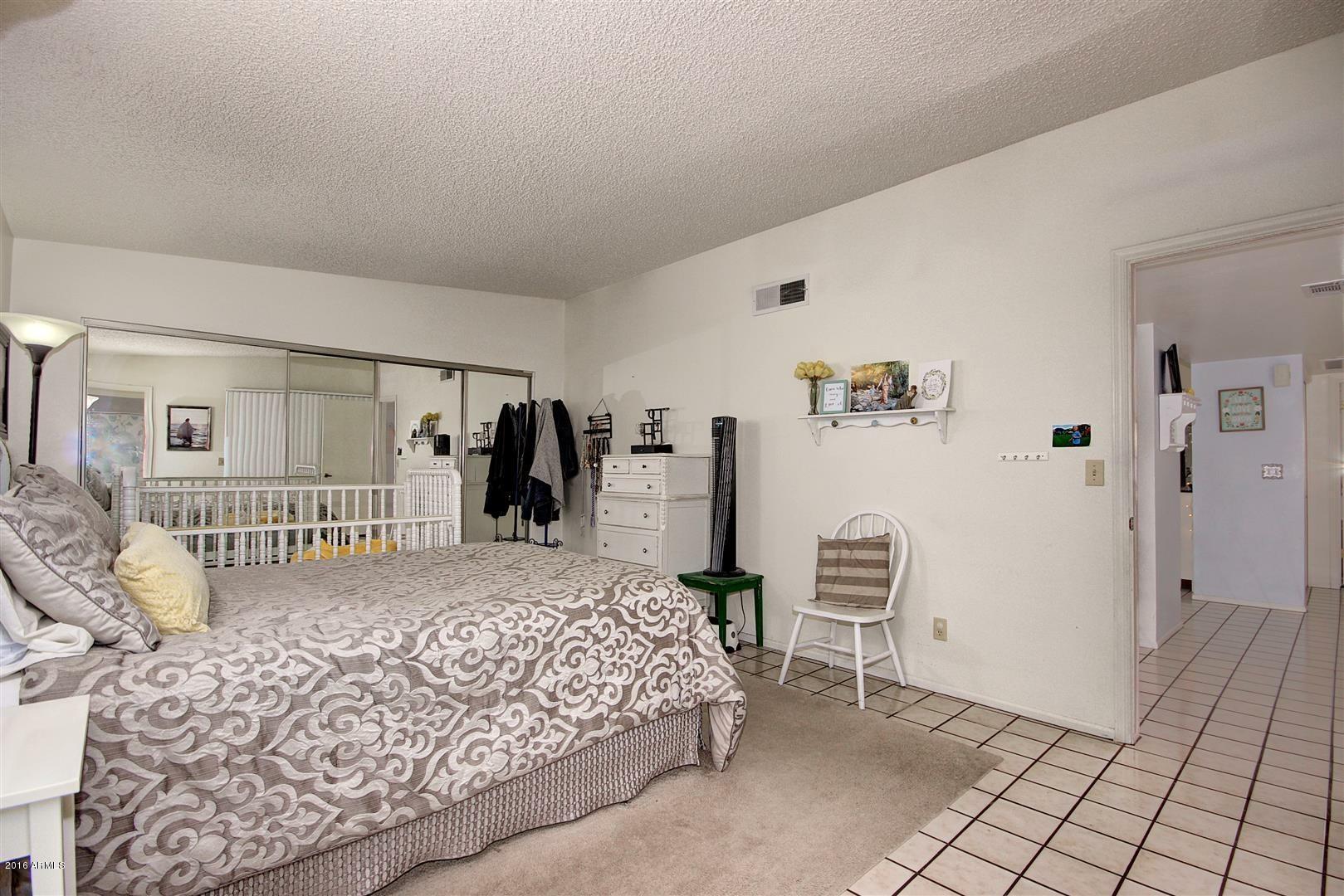 2929 East Broadway Road, Unit 102 Mesa, AZ 85204 - Photo 13 of 16 a bedroom with a large bed and a window