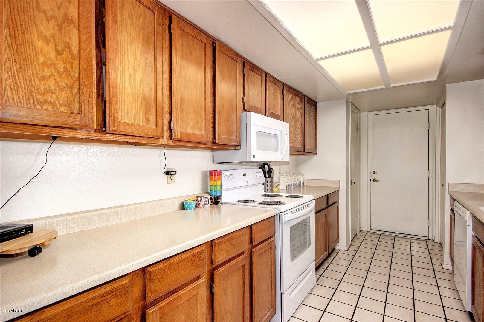 2929 East Broadway Road, Unit 102 Mesa, AZ 85204 - Photo 7 of 16 a kitchen with stainless steel appliances a sink stove and cabinets