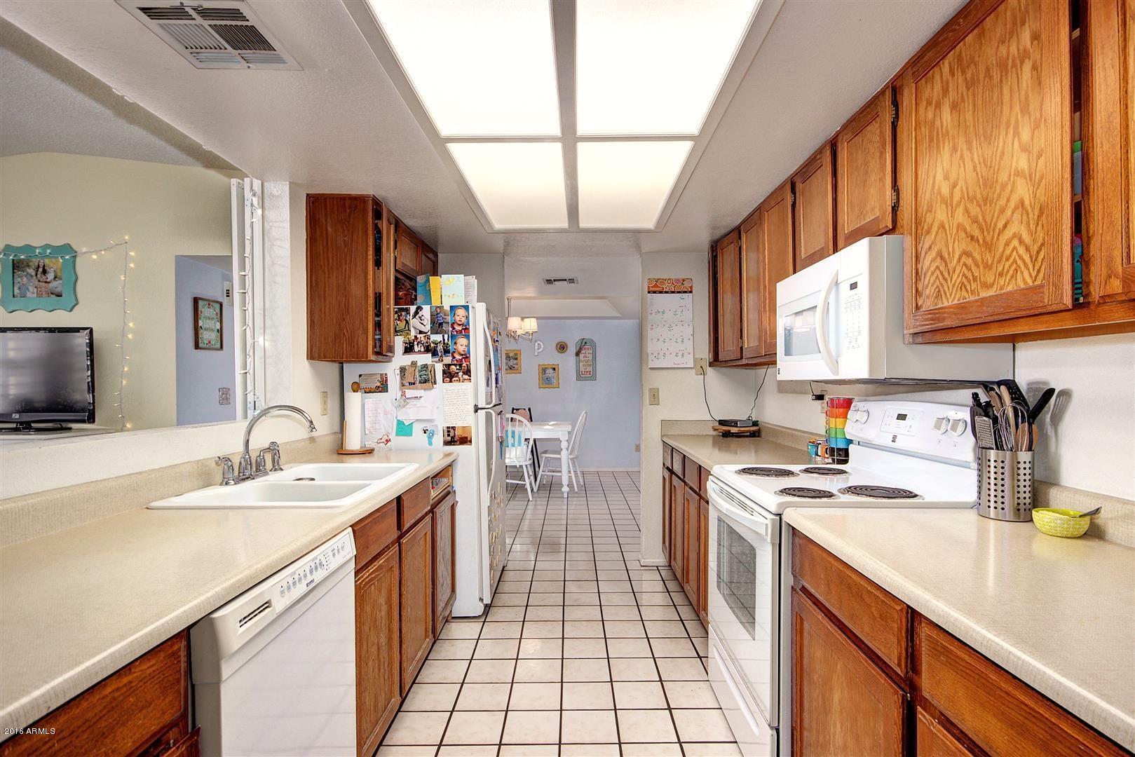 2929 East Broadway Road, Unit 102 Mesa, AZ 85204 - Photo 8 of 16 a kitchen with stainless steel appliances a sink stove and cabinets