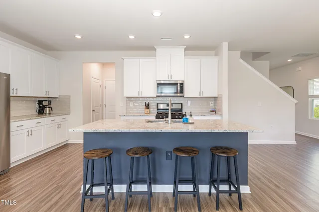 a kitchen with a sink a microwave a refrigerator and wooden floor