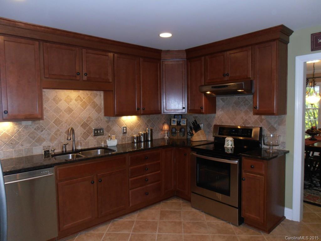 11031 Painted Tree Road Charlotte, NC 28226 - Photo 3 of 15 a kitchen with granite countertop wooden cabinets and a sink
