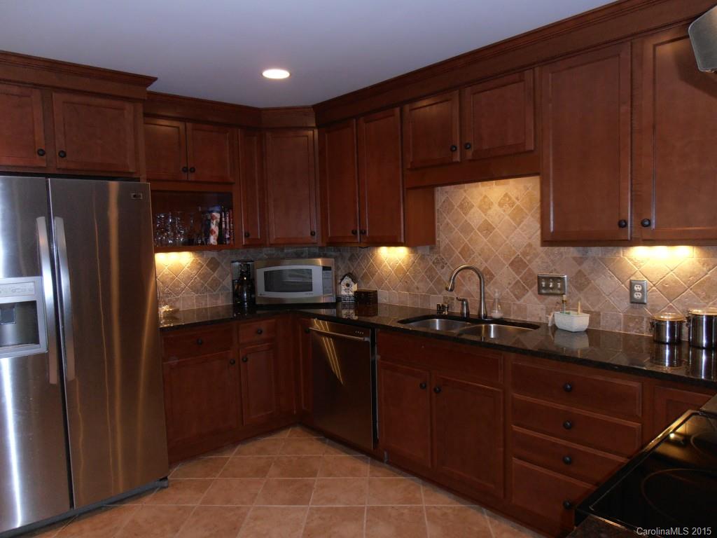 11031 Painted Tree Road Charlotte, NC 28226 - Photo 6 of 15 a kitchen with sink a refrigerator and cabinets