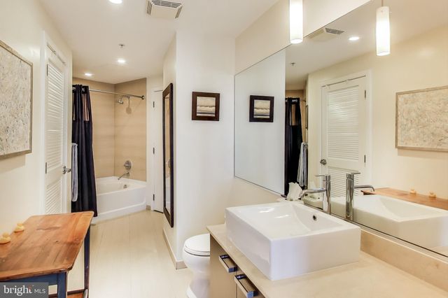 a bathroom with a tub sink and mirror