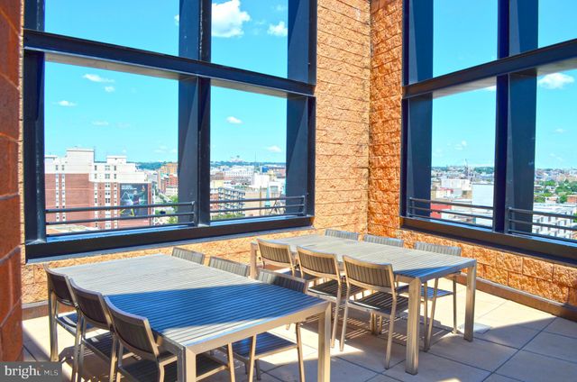 a view of a dining room with furniture and large windows