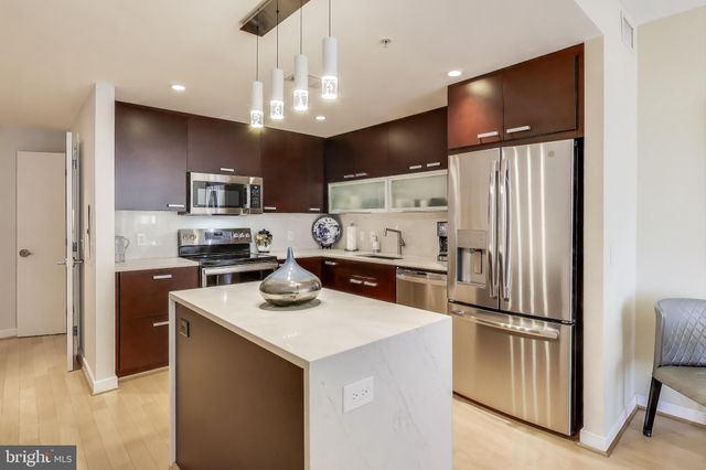 a kitchen with kitchen island a counter top space stainless steel appliances and cabinets