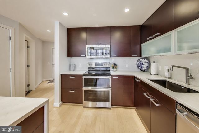 a kitchen with kitchen island white cabinets and refrigerator