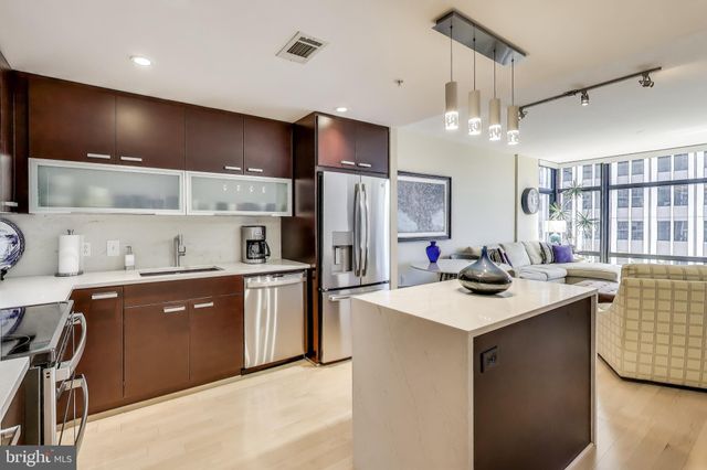 a kitchen with stainless steel appliances kitchen island a sink stove and refrigerator