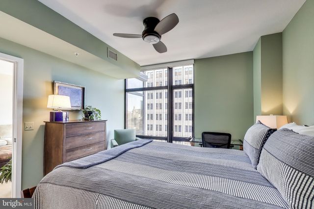 a spacious bedroom with a bed and a large window