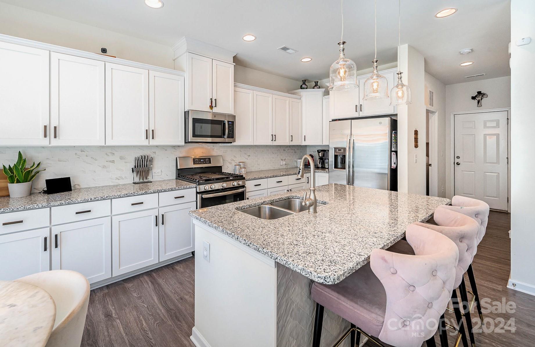 641 Amber Meadows Way Tega Cay, SC 29708 - Photo 11 of 28 a kitchen with stainless steel appliances granite countertop a table chairs sink refrigerator and cabinets