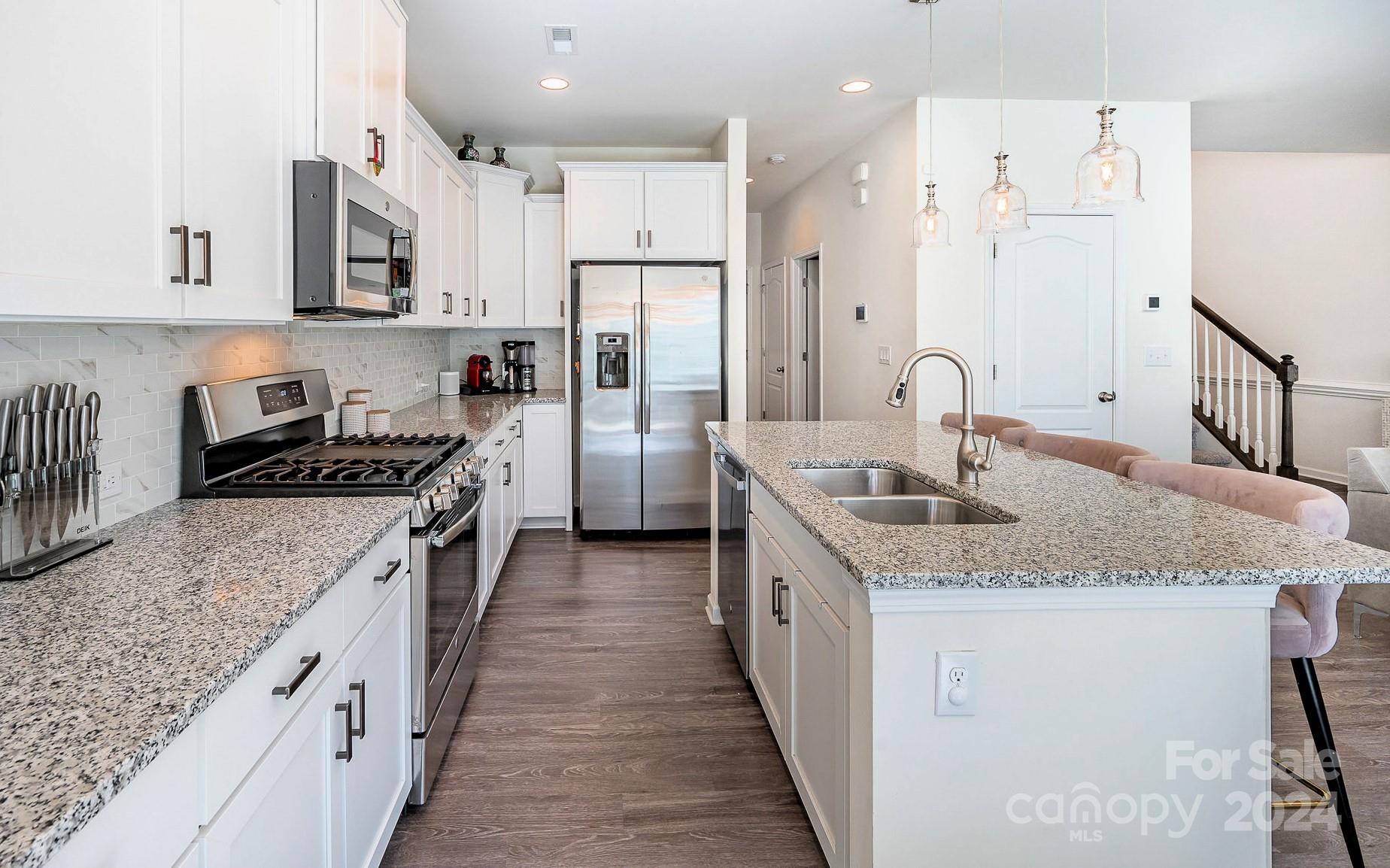 641 Amber Meadows Way Tega Cay, SC 29708 - Photo 12 of 28 a kitchen with stainless steel appliances granite countertop a sink stove and refrigerator