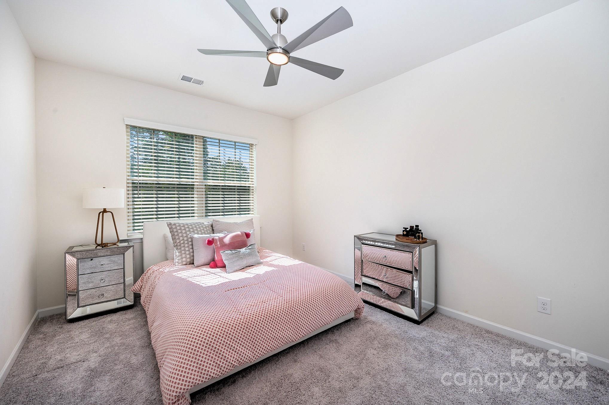 641 Amber Meadows Way Tega Cay, SC 29708 - Photo 22 of 28 a bedroom with a bed and a chandelier