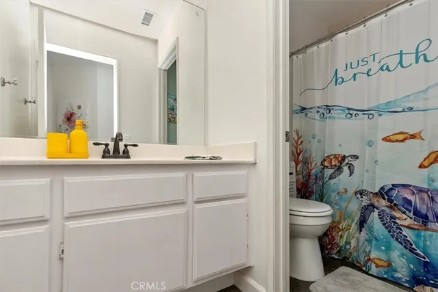 a bathroom with a sink a toilet and a mirror