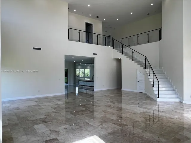 a view of staircase with lots of frames on wall and a window