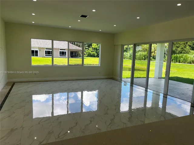 a bathroom with a granite countertop sink a large mirror and a bathtub