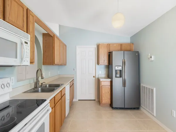 a kitchen with stainless steel appliances granite countertop a refrigerator and a sink